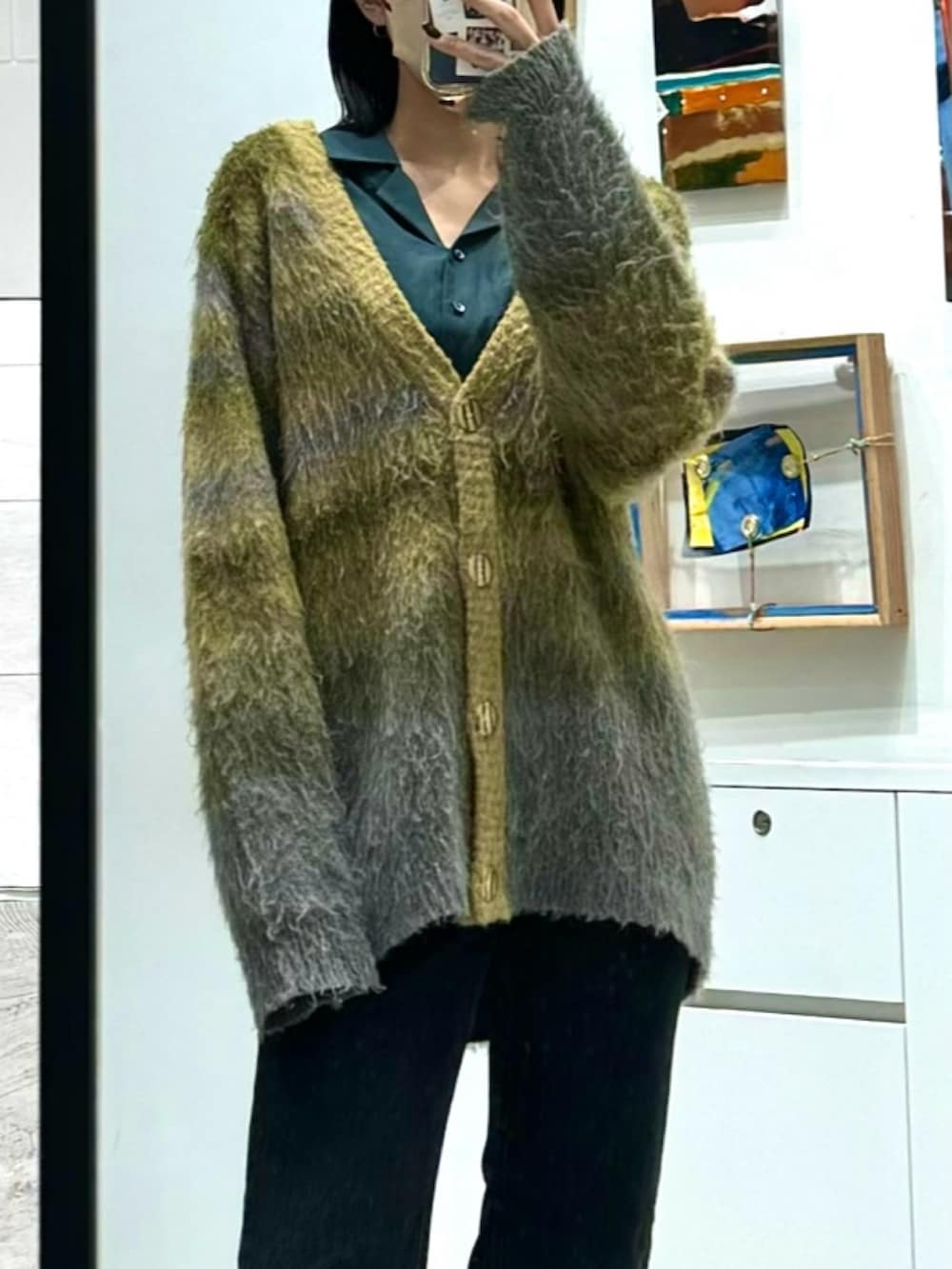 ブラック系のデニムパンツ、グリーン系のカーディガン/ボレロ、グリーン系のシャツ/ブラウスを着用したレディースの秋コーディネートの2枚目の写真