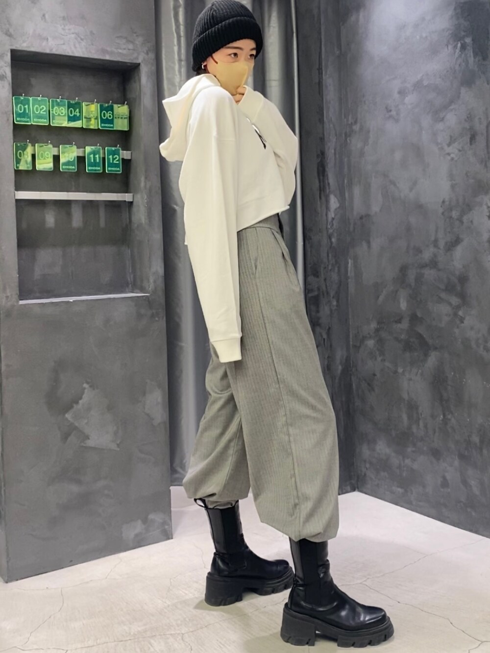 ブラック系のブーツ、グレー系のその他パンツ、ホワイト系のパーカーを着用したレディースの冬コーディネートの5枚目の写真