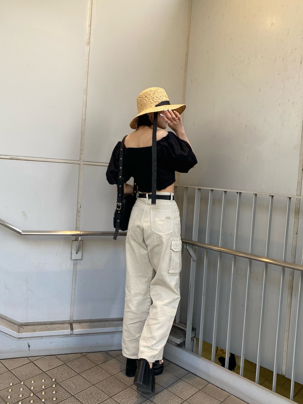 ブラック系のサンダル、ホワイト系のデニムパンツ、ブラック系のシャツ/ブラウスを着用したレディースの春コーディネートの3枚目の写真