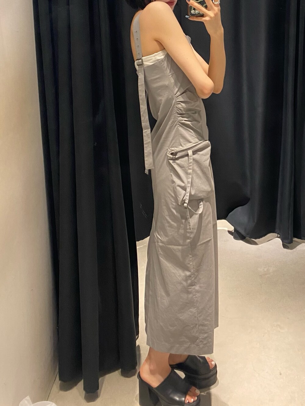 グレー系のワンピース、ブラック系のサンダル、ホワイト系のキャミソールを着用したレディースの夏コーディネートの4枚目の写真