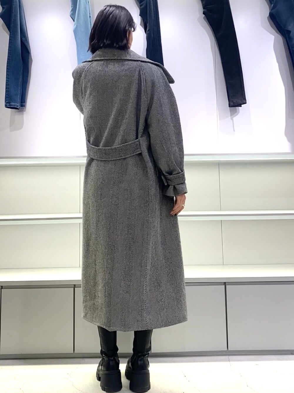 その他のチェスターコート、ブラック系のブーツ、ブラック系のニット/セーターを着用したレディースの秋コーディネートの6枚目の写真