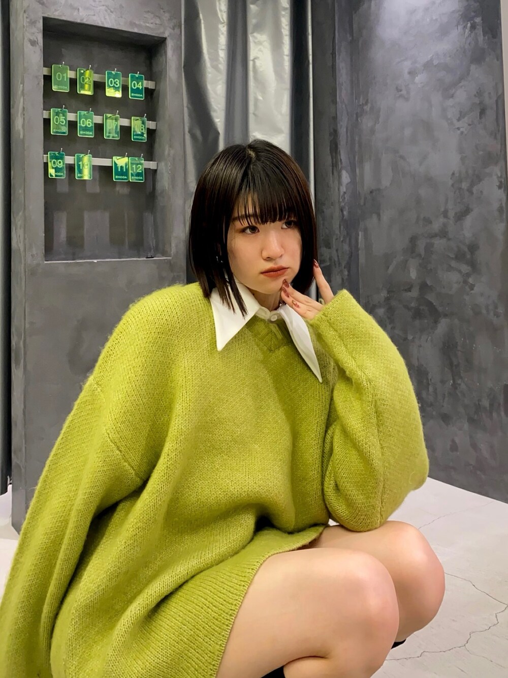 ブラック系のブーツ、イエロー系のニット/セーター、ホワイト系のワンピースを着用したレディースの冬コーディネートの6枚目の写真