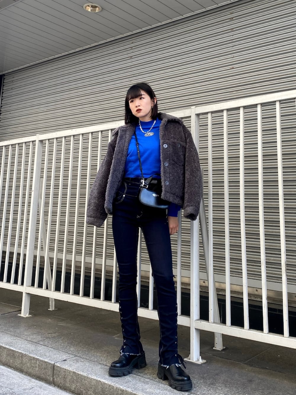 ブルー系のデニムパンツ、ブラック系のブーツ、ブルー系のスウェットを着用したレディースの冬コーディネートの2枚目の写真