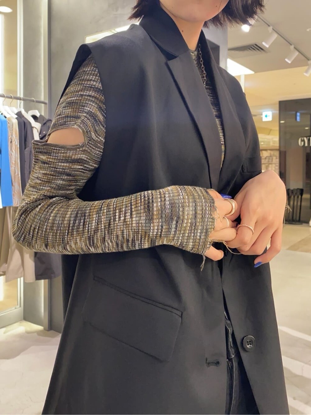 ブラック系のローファー、ブラック系のベスト、ブラック系のデニムパンツを着用したレディースの秋コーディネートの3枚目の写真