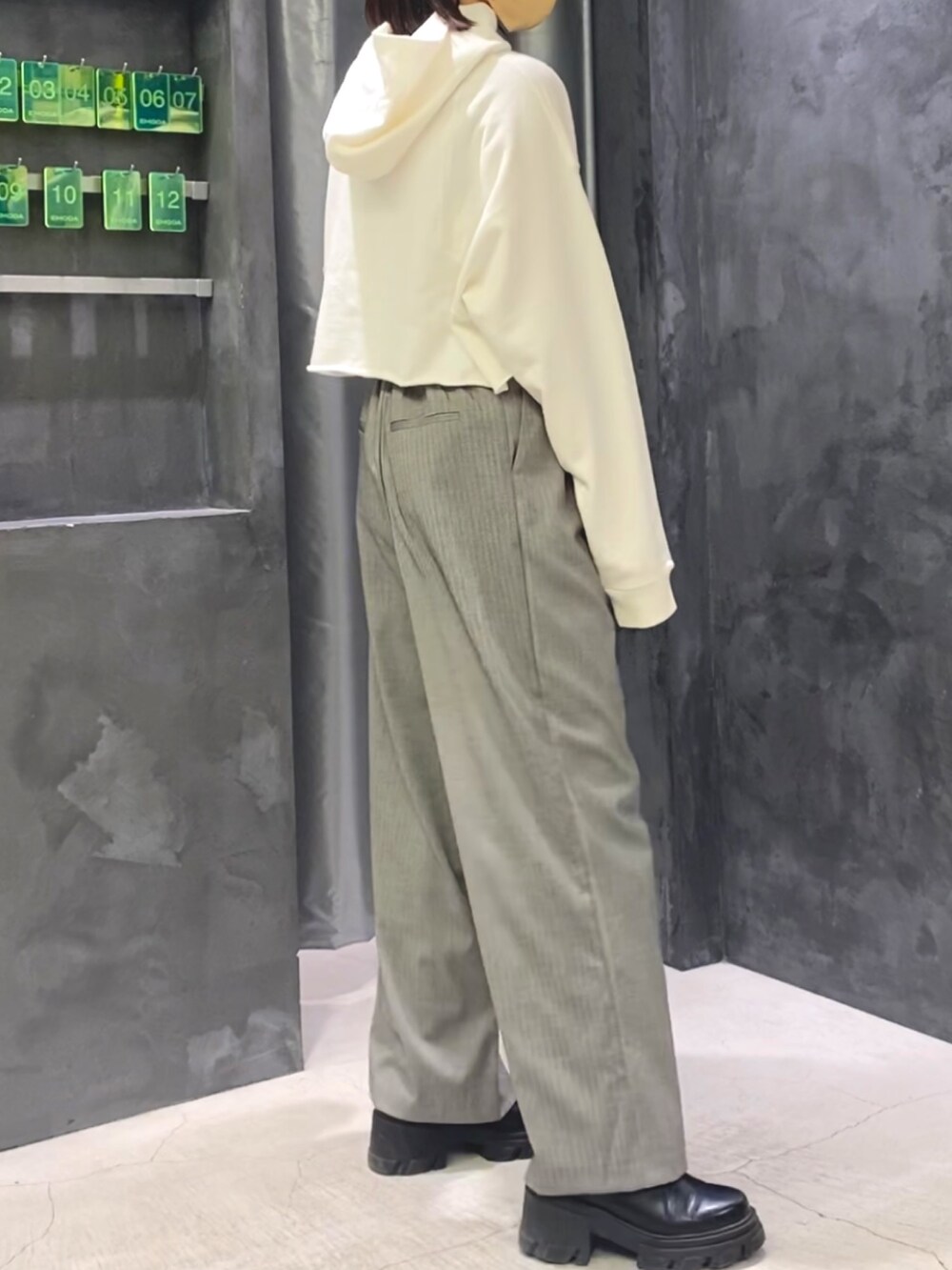 ブラック系のブーツ、グレー系のその他パンツ、ホワイト系のパーカーを着用したレディースの冬コーディネートの3枚目の写真