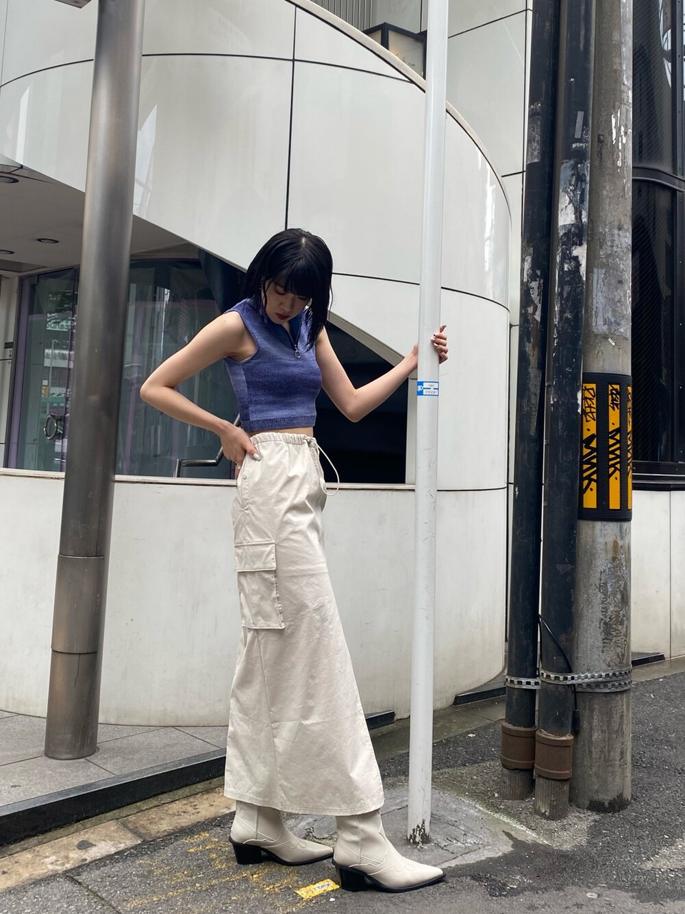 ホワイト系のブーツ、ホワイト系のスカート、ブルー系のタンクトップを着用したレディースの春コーディネートの3枚目の写真