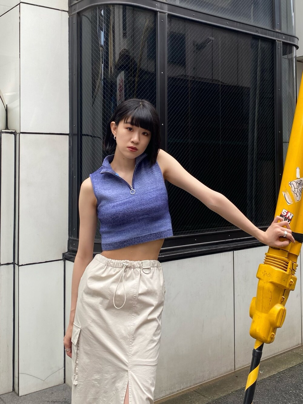 ホワイト系のブーツ、ホワイト系のスカート、ブルー系のタンクトップを着用したレディースの春コーディネートの5枚目の写真