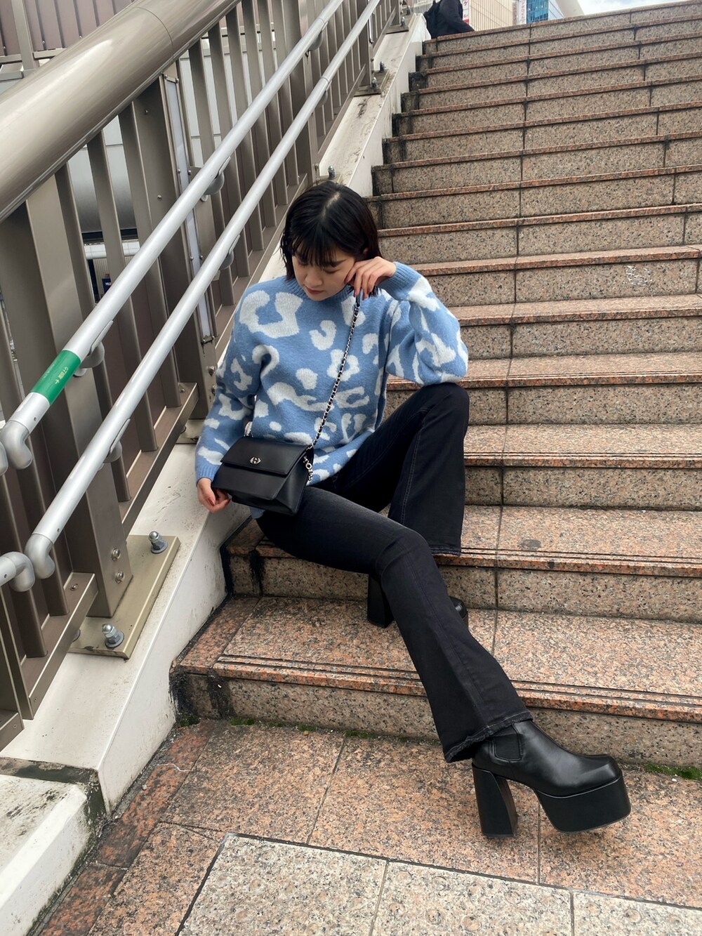 ブルー系のニット/セーター、ブラック系のハンドバッグ、ブラック系のブーツを着用したレディースの冬コーディネートの8枚目の写真