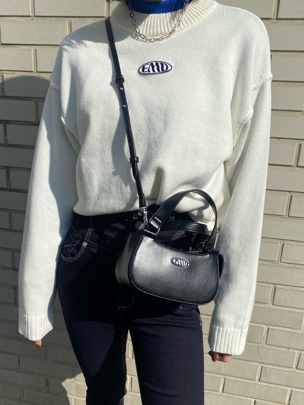 ブラック系のブーツ、ブラック系のハンドバッグ、グレー系のブルゾンを着用したレディースの冬コーディネートの9枚目の写真