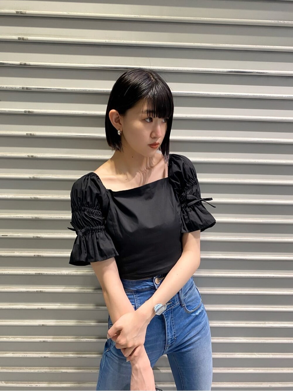 ブルー系のデニムパンツ、ブラック系のサンダル、ブラック系のシャツ/ブラウスを着用したレディースの夏コーディネートの5枚目の写真