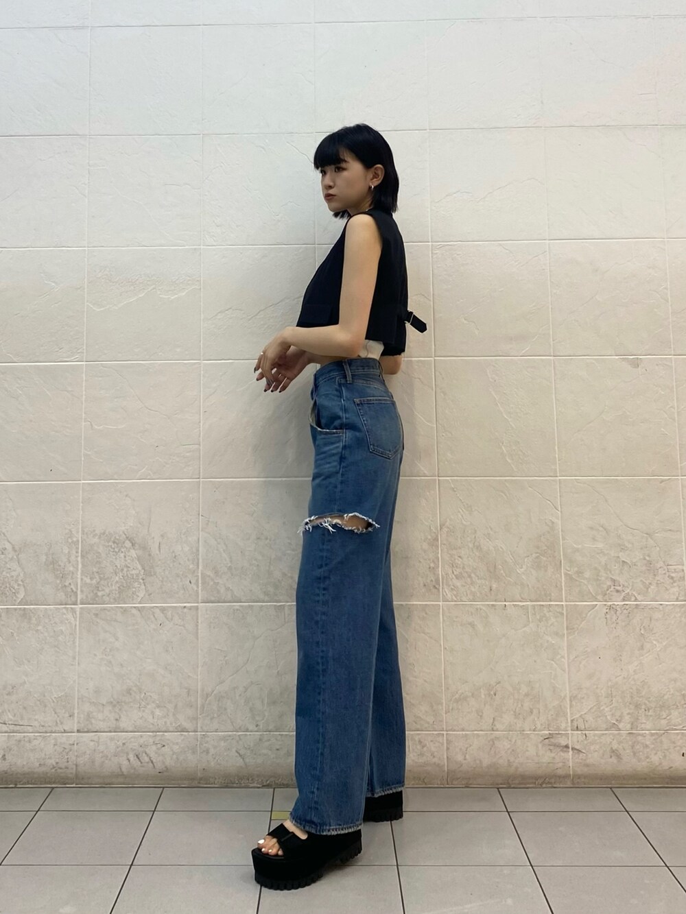 ブラック系のサンダル、ブルー系のデニムパンツ、ホワイト系のニット/セーターを着用したレディースの夏コーディネートの3枚目の写真