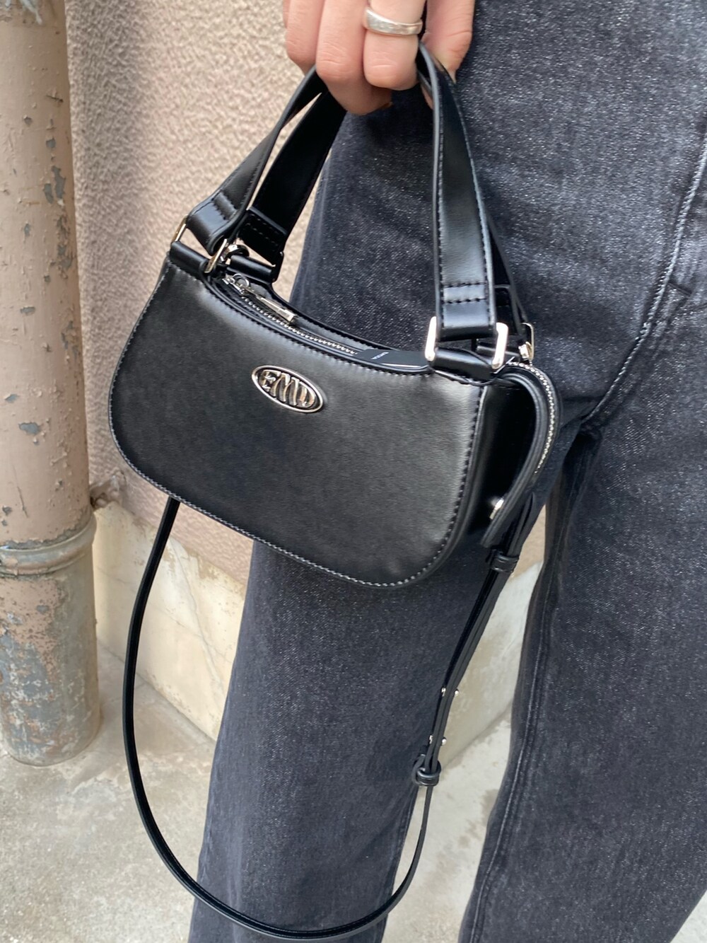 ブラック系のデニムパンツ、ブラック系のブーツ、ブラック系のハンドバッグを着用したレディースの春コーディネートの8枚目の写真