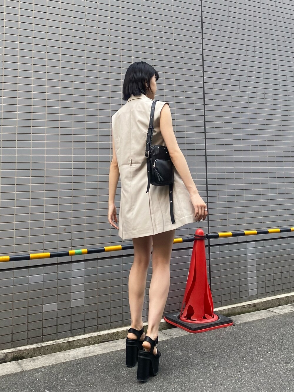 ブラック系のサンダル、ホワイト系のワンピース、ブラック系のニット/セーターを着用したレディースの春コーディネートの4枚目の写真