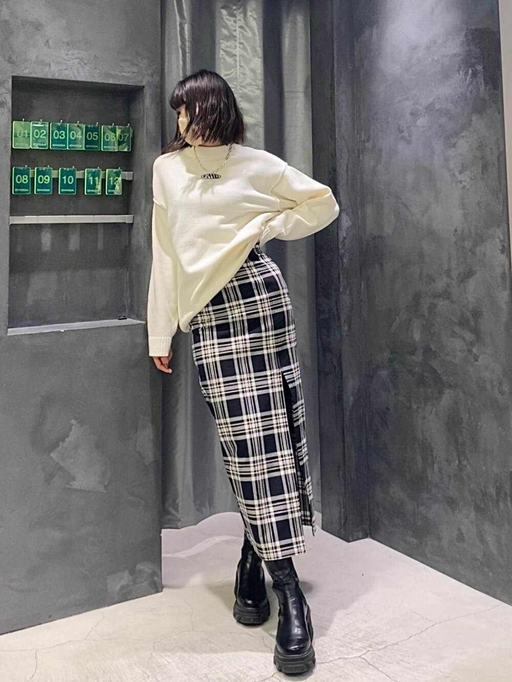 その他のスカート、ホワイト系のニット/セーター、ブラック系のブーツを着用したレディースの冬コーディネートの3枚目の写真