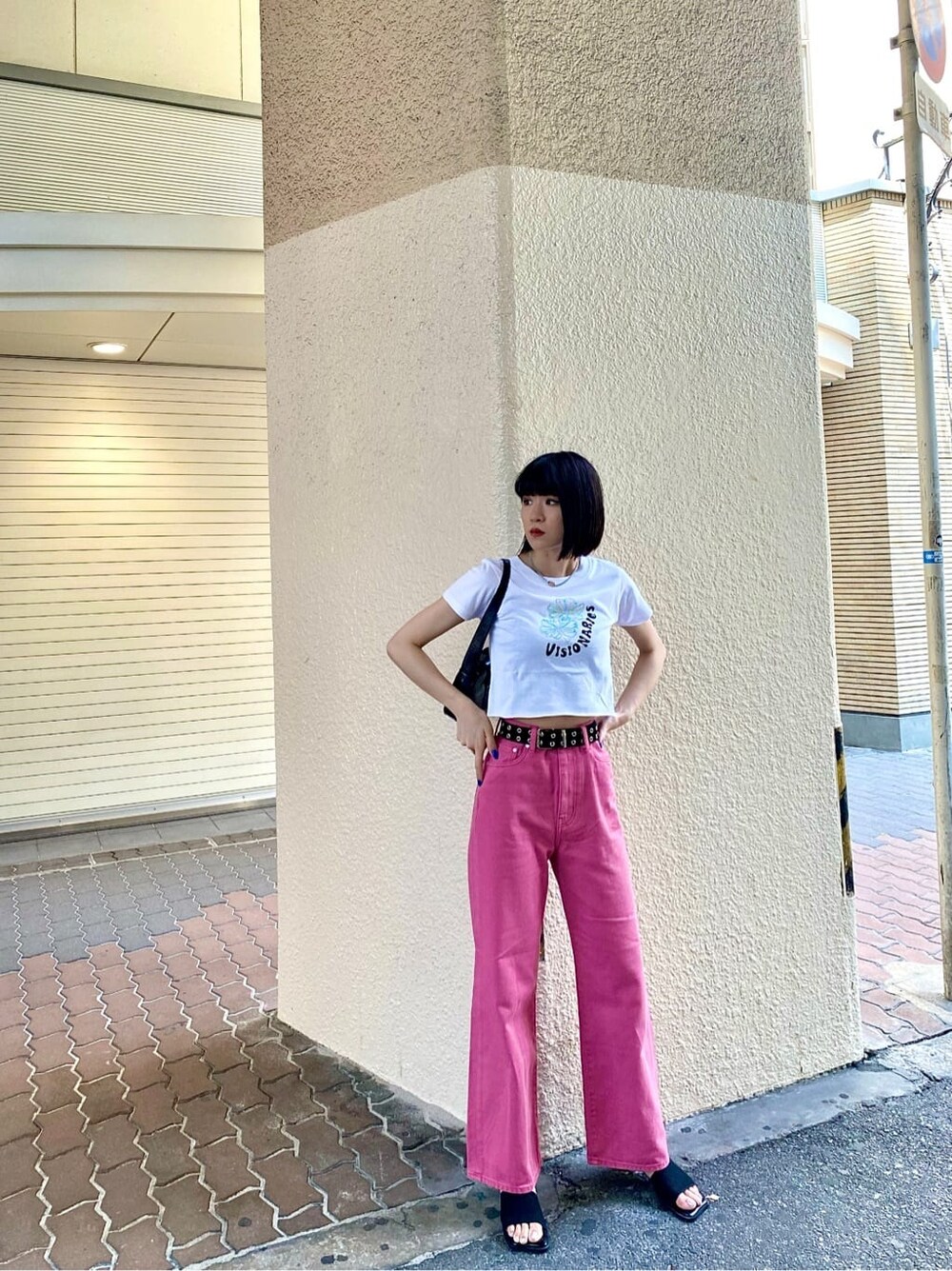 ピンク系のデニムパンツ、ホワイト系のTシャツ/カットソー、ブラック系のサンダルを着用したレディースの夏コーディネートの2枚目の写真