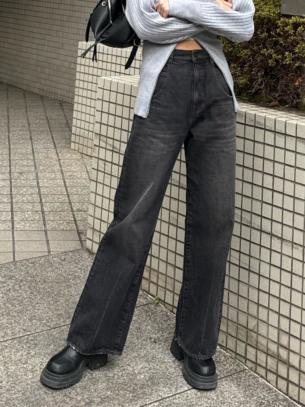 ブラック系のブーツ、ブラック系のデニムパンツ、グレー系のニット/セーターを着用したレディースの冬コーディネートの10枚目の写真