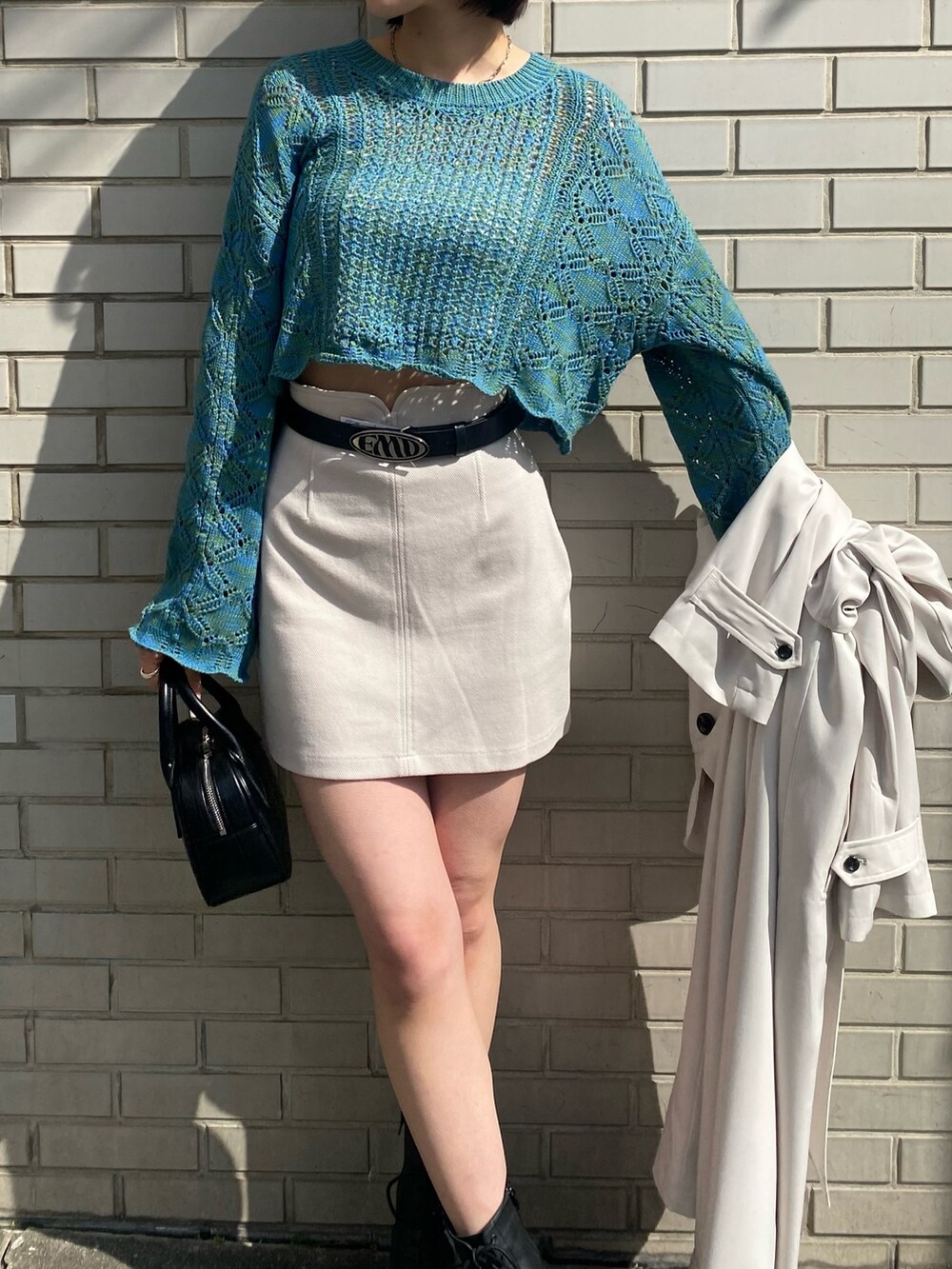 ホワイト系のスカート、ブルー系のニット/セーター、ホワイト系のトレンチコートを着用したレディースの春コーディネートの8枚目の写真