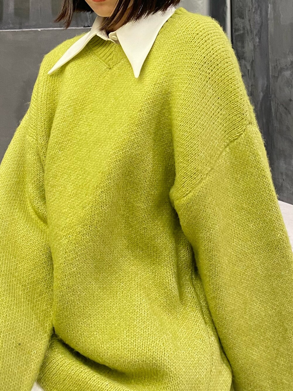 ブラック系のブーツ、イエロー系のニット/セーター、ホワイト系のワンピースを着用したレディースの冬コーディネートの7枚目の写真