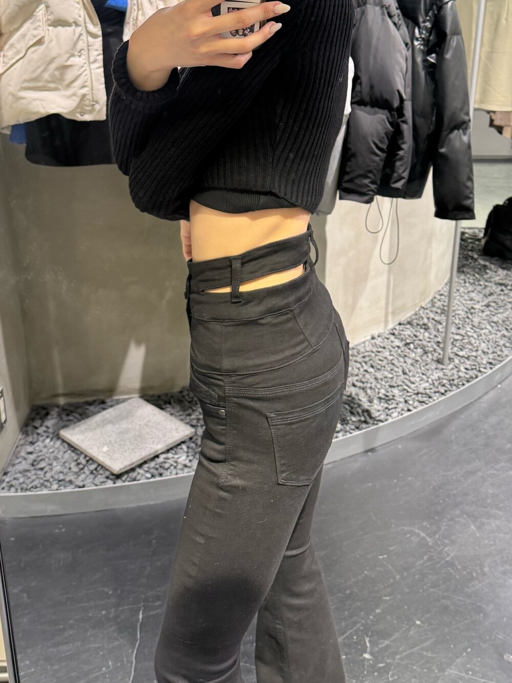 ブラック系のブーツ、ブラック系のデニムパンツ、ブラック系のニット/セーターを着用したレディースの冬コーディネートの3枚目の写真