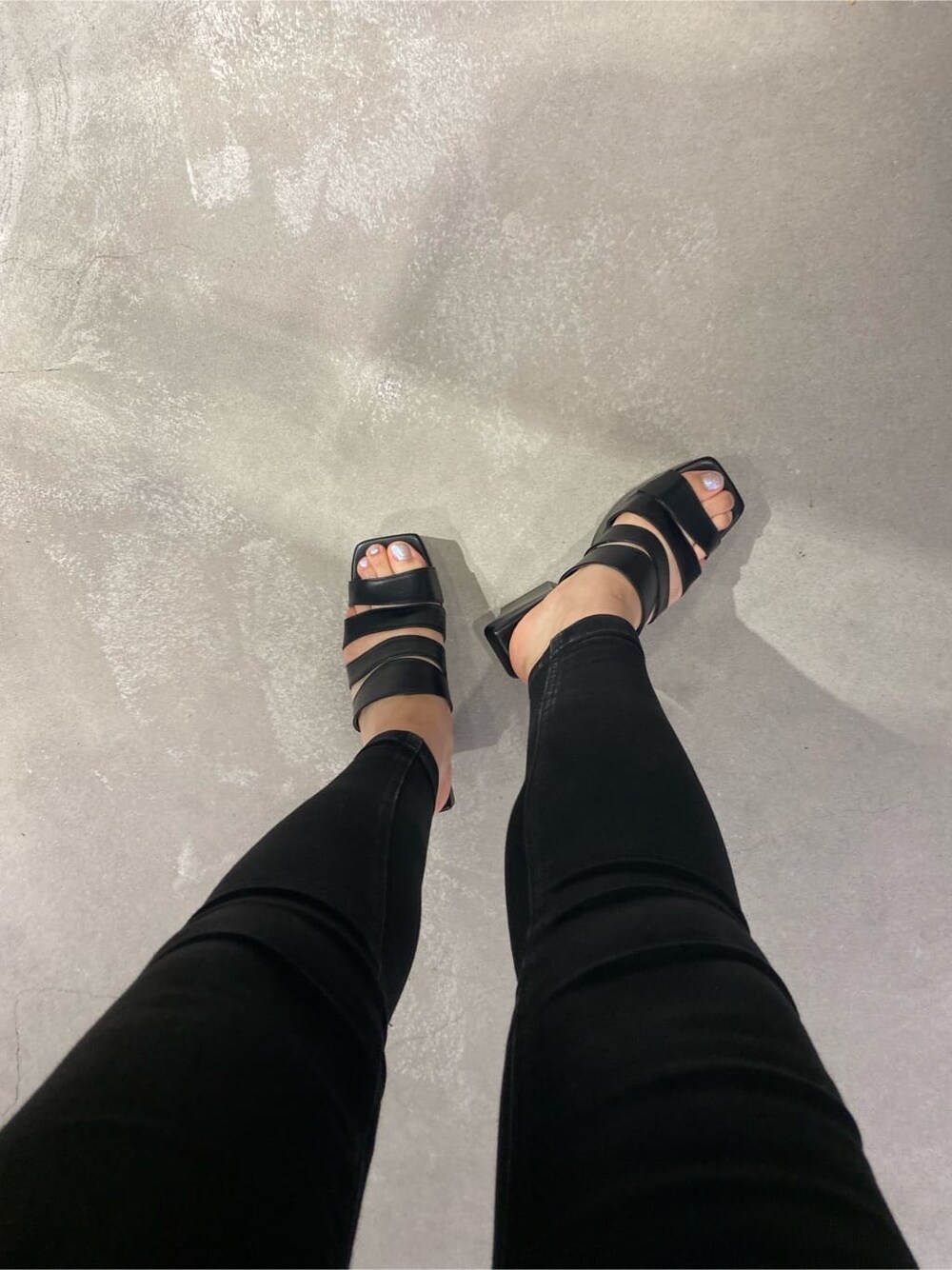 ブラック系のニット/セーター、ブラック系のサンダル、ブラック系のデニムパンツを着用したレディースの夏コーディネートの6枚目の写真