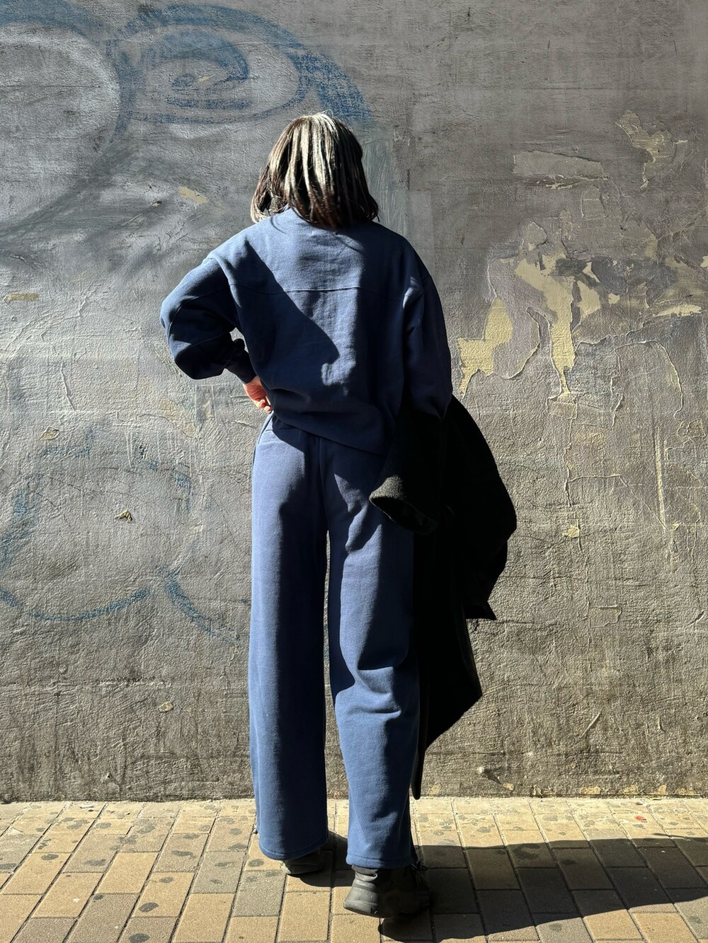 ブルー系のTシャツ/カットソー、ブルー系のTシャツ/カットソー、ブラック系のチェスターコートを着用したレディースの秋コーディネートの4枚目の写真