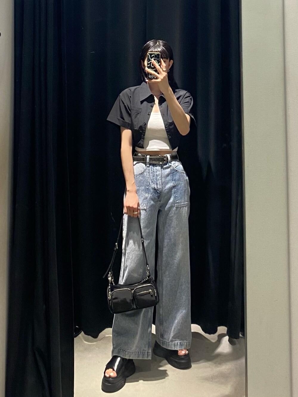 ブラック系のサンダル、ブルー系のデニムパンツ、ブラック系のシャツ/ブラウスを着用したレディースの夏コーディネートの4枚目の写真