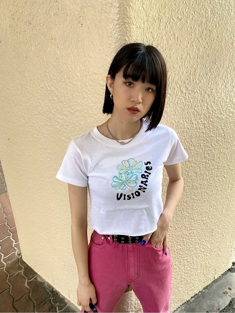 ピンク系のデニムパンツ、ブラック系のハンドバッグ、ホワイト系のTシャツ/カットソーを着用したレディースの夏コーディネートの2枚目の写真
