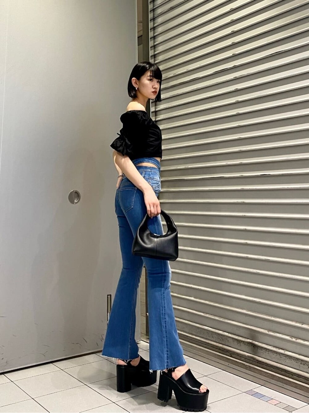 ブルー系のデニムパンツ、ブラック系のサンダル、ブラック系のシャツ/ブラウスを着用したレディースの夏コーディネートの2枚目の写真