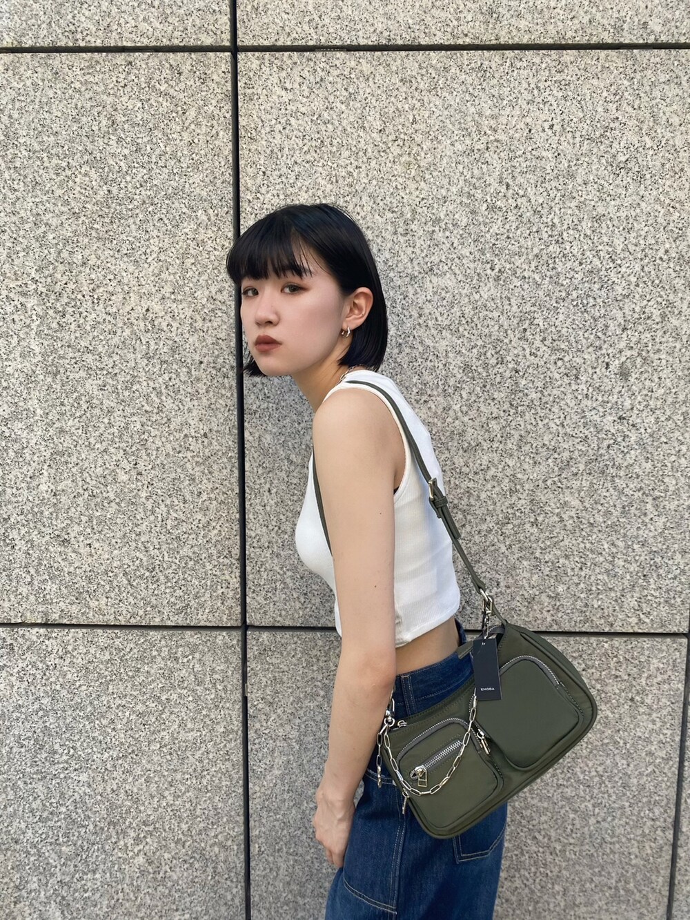 ブラック系のサンダル、ブルー系のデニムパンツ、ホワイト系のタンクトップを着用したレディースの夏コーディネートの7枚目の写真