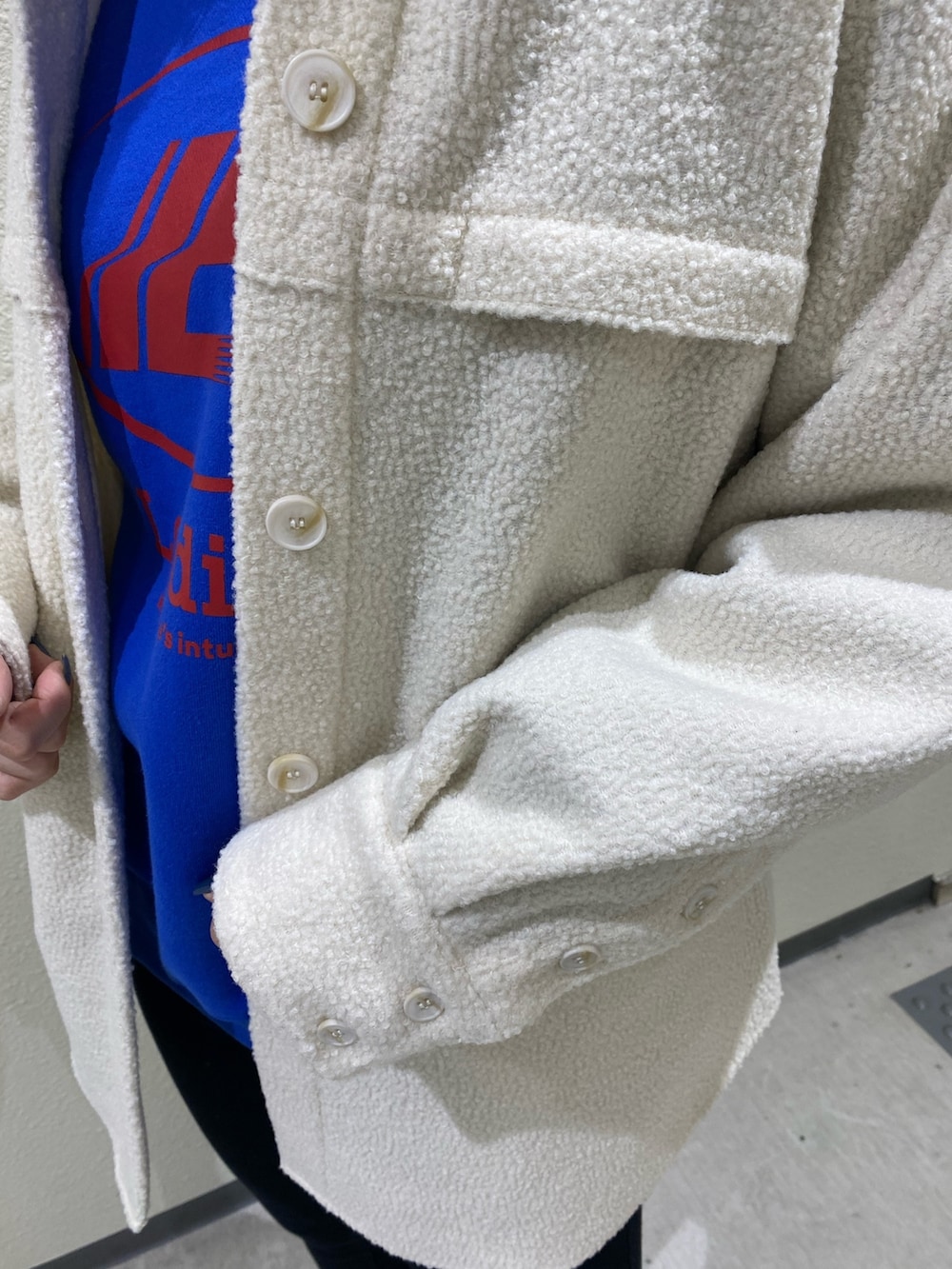 ホワイト系のブルゾン、ブラック系のその他パンツ、ブラック系のブーツを着用したレディースの冬コーディネートの9枚目の写真