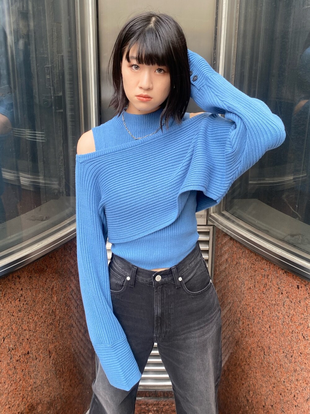 ブラック系のブーツ、ブラック系のデニムパンツ、ブルー系のニット/セーターを着用したレディースの秋コーディネートの4枚目の写真