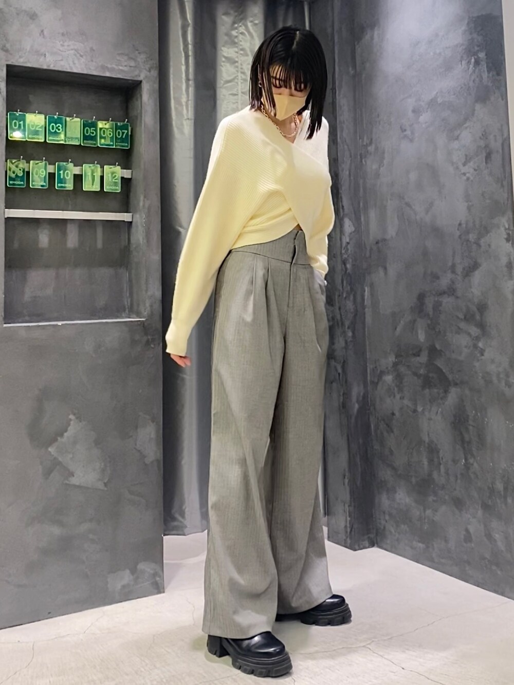 ブラック系のブーツ、グレー系のその他パンツ、ホワイト系のニット/セーターを着用したレディースの冬コーディネートの6枚目の写真