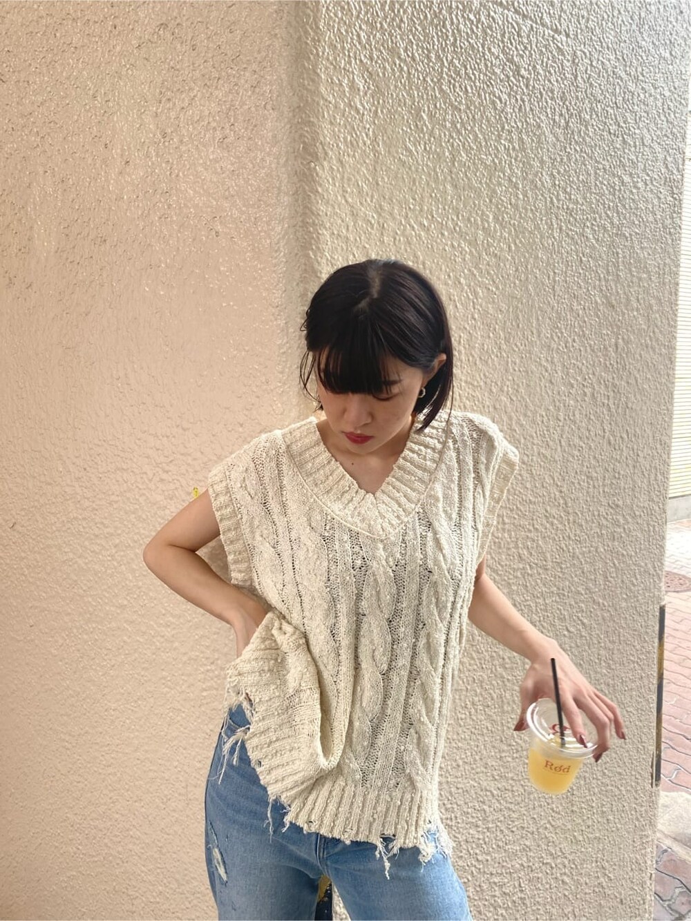 ブルー系のデニムパンツ、ベージュ系のスリッポン、ホワイト系のベストを着用したレディースの夏コーディネートの4枚目の写真