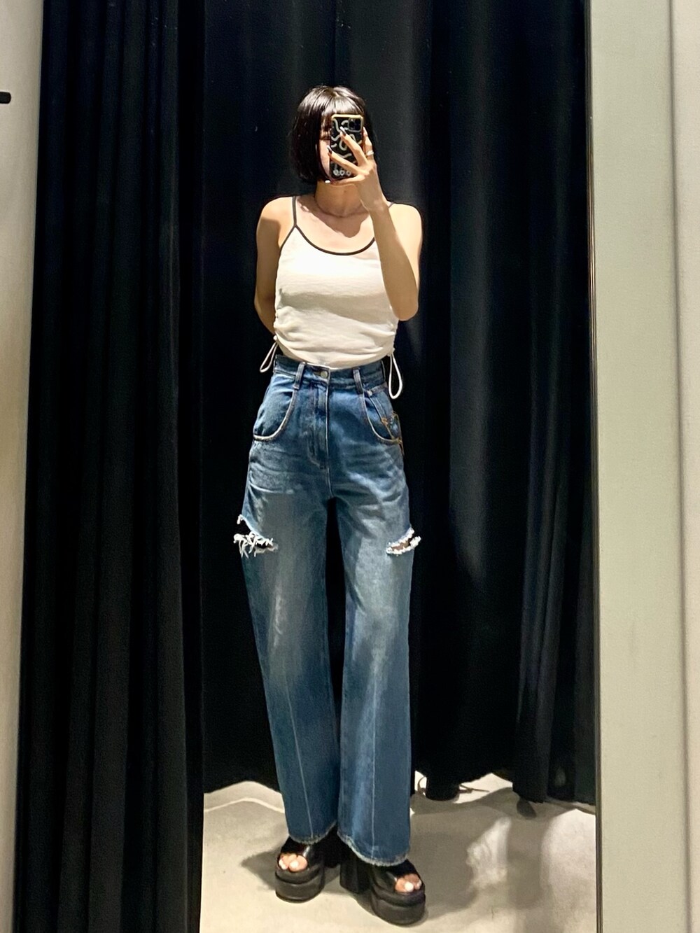 ブラック系のサンダル、ブルー系のデニムパンツ、ホワイト系のTシャツ/カットソーを着用したレディースの夏コーディネートの5枚目の写真