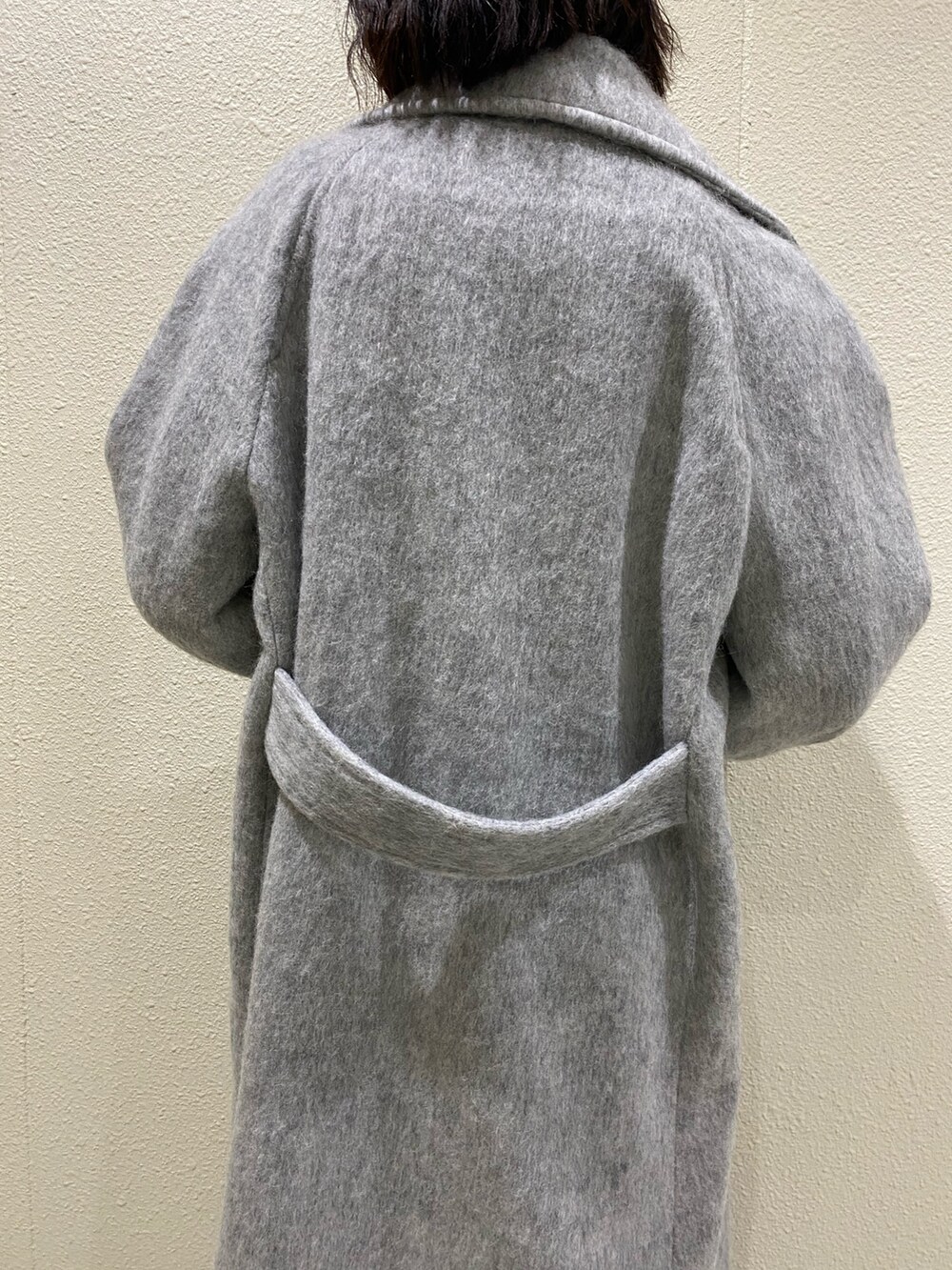 ブラック系のブーツ、グレー系のチェスターコート、ブラック系のスカートを着用したレディースの冬コーディネートの7枚目の写真