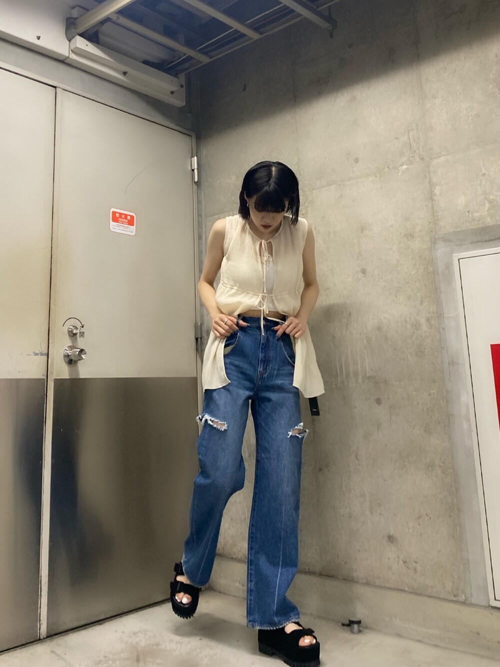 ブラック系のサンダル、ブルー系のデニムパンツ、ホワイト系のTシャツ/カットソーを着用したレディースの夏コーディネートの4枚目の写真