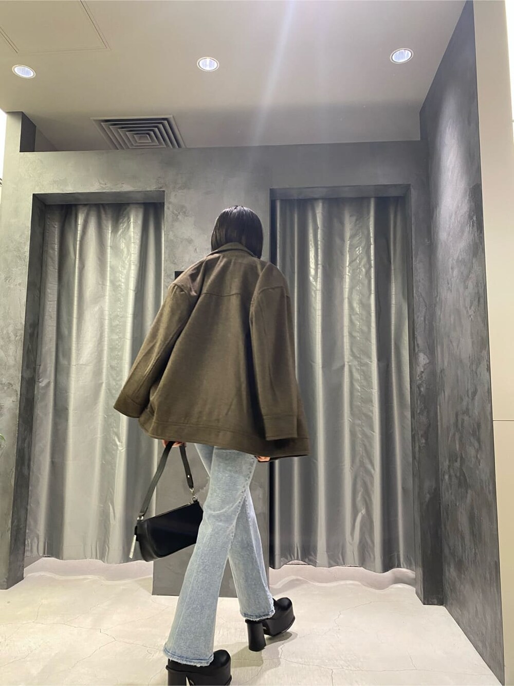 ブラック系のブーツ、ブラウン系のテーラードジャケット、ブルー系のデニムパンツを着用したレディースの秋コーディネートの6枚目の写真