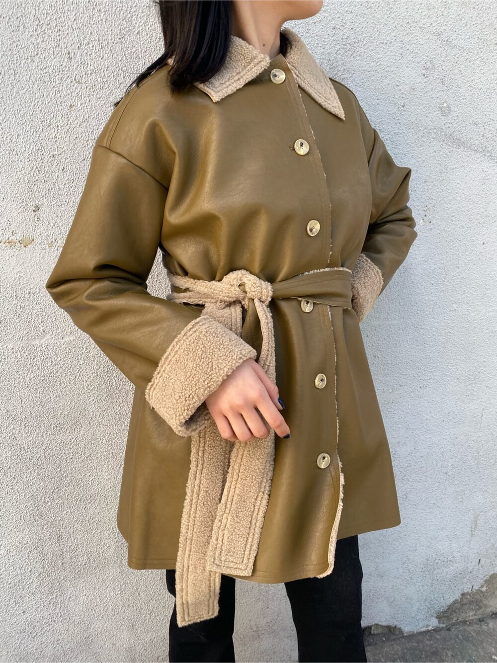 ホワイト系のニット/セーター、ホワイト系のハンドバッグ、ベージュ系のムートンコートを着用したレディースの冬コーディネートの4枚目の写真