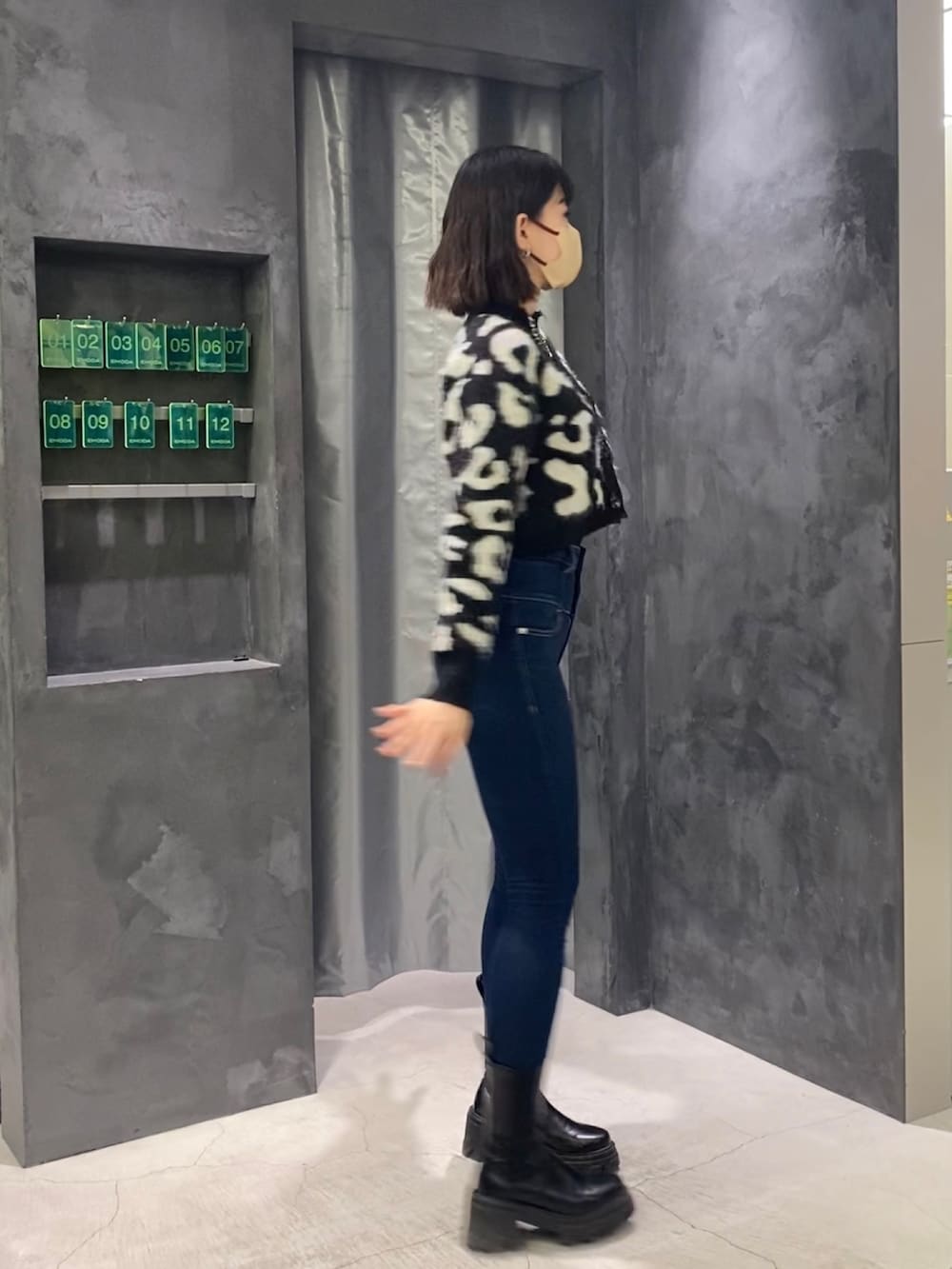 ブルー系のデニムパンツ、ブラック系のブーツ、ブラック系のカーディガン/ボレロを着用したレディースの冬コーディネートの2枚目の写真