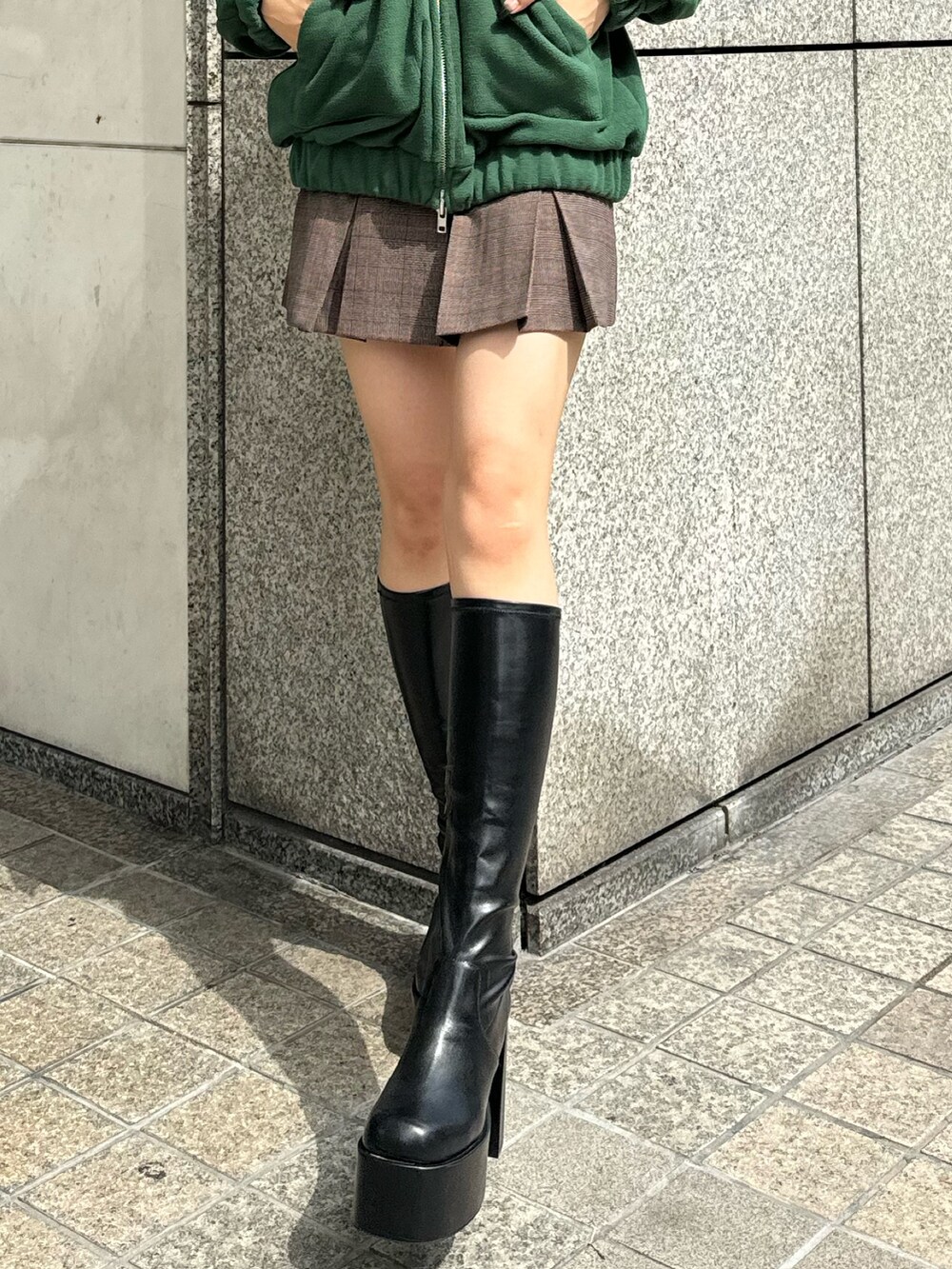 ブラック系のブーツ、その他のスカート、グリーン系のブルゾンを着用したレディースの秋コーディネートの4枚目の写真