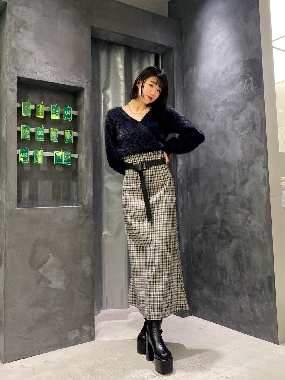 ブラック系のブーツ、ブラック系のニット/セーター、その他のスカートを着用したレディースの冬コーディネートの2枚目の写真