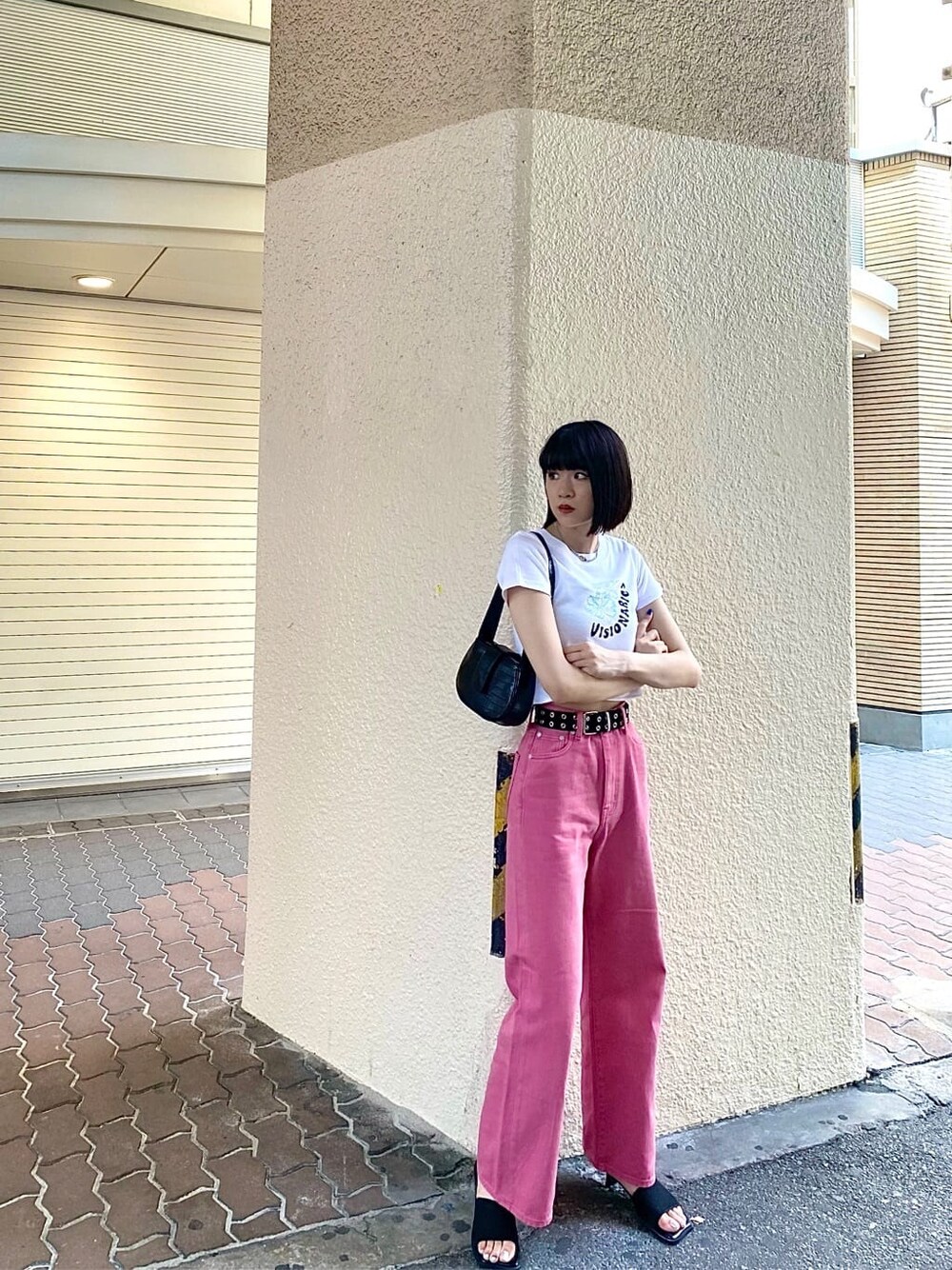 ピンク系のデニムパンツ、ブラック系のハンドバッグ、ホワイト系のTシャツ/カットソーを着用したレディースの夏コーディネートの5枚目の写真