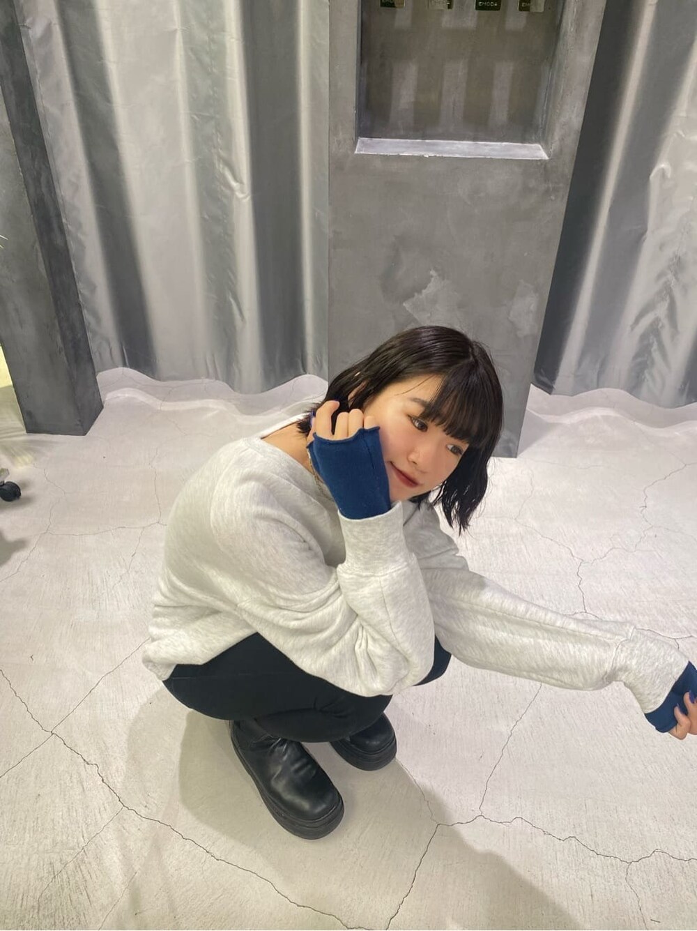 ブラック系のベスト、グレー系のスウェット、ブルー系のアームカバーを着用したレディースの秋コーディネートの2枚目の写真