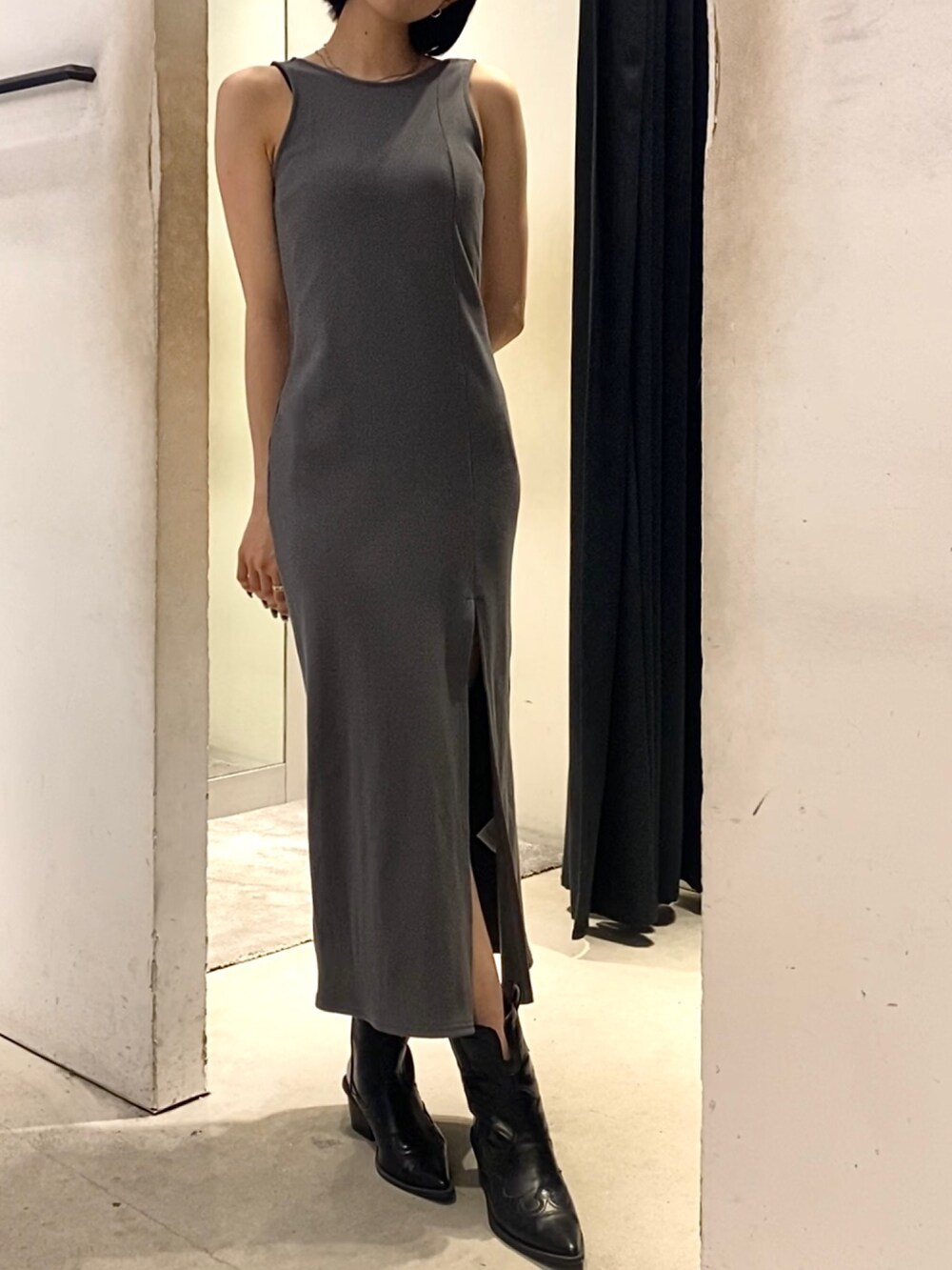 グレー系のワンピース、ブラック系のブーツを着用したレディースの夏コーディネートの2枚目の写真