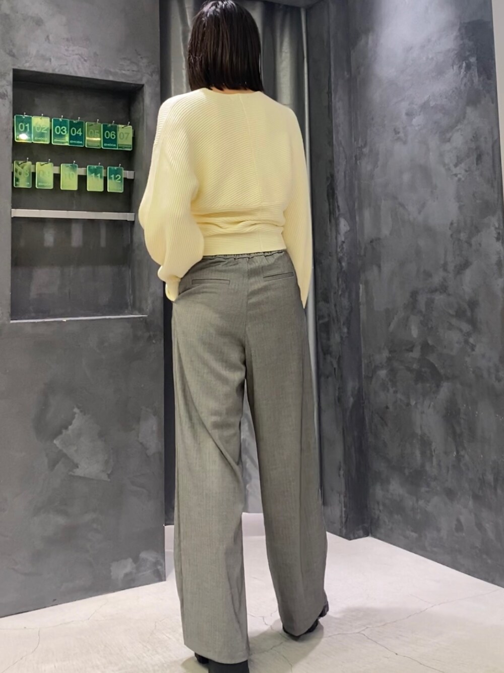 ブラック系のブーツ、グレー系のその他パンツ、ホワイト系のニット/セーターを着用したレディースの冬コーディネートの5枚目の写真