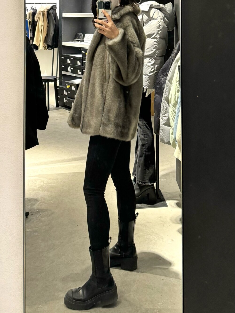 ブラック系のブーツ、ブラック系のデニムパンツ、グレー系のその他アウターを着用したレディースの冬コーディネートの2枚目の写真