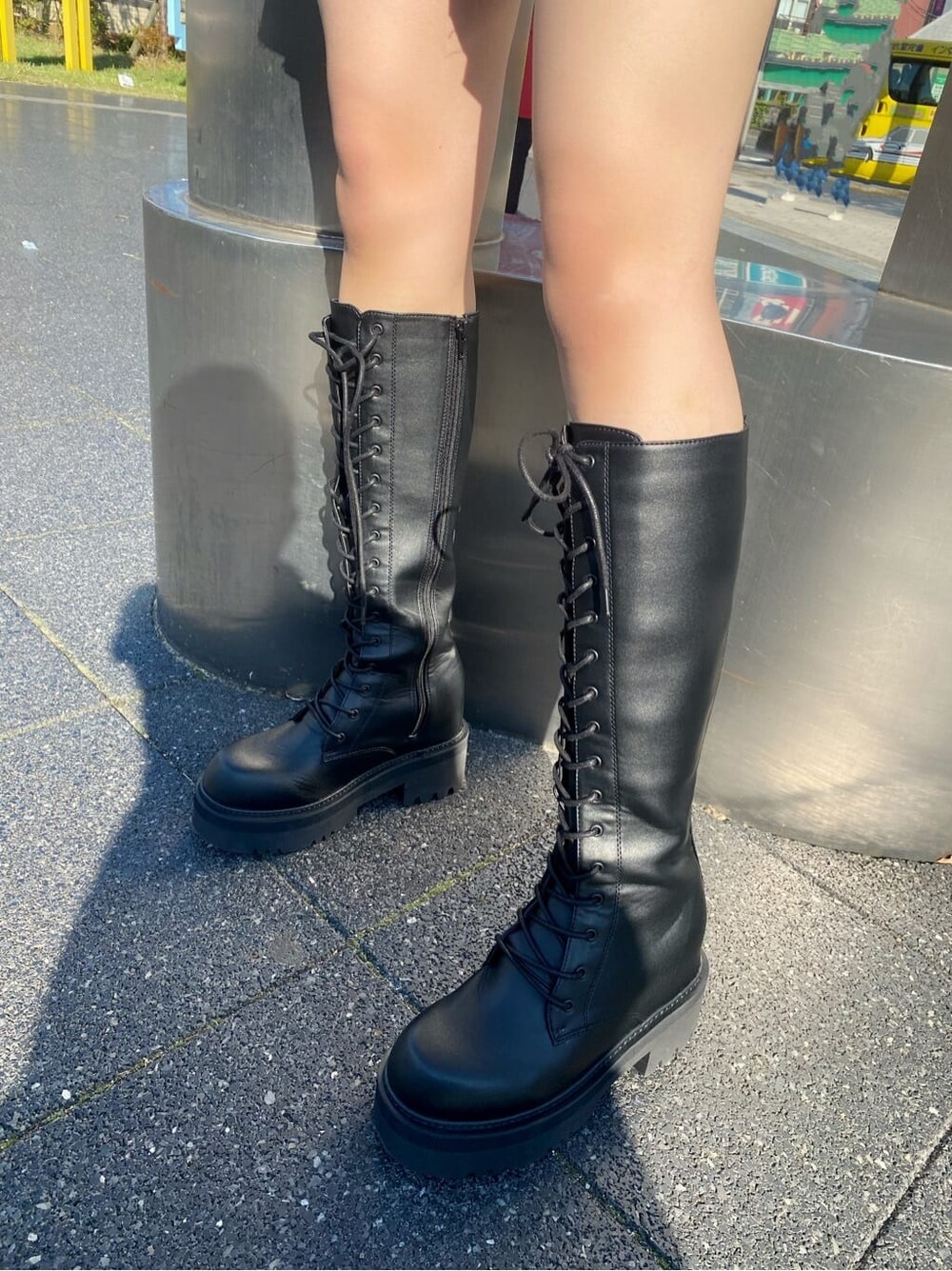 ブラック系のブーツ、ブルー系のブルゾン、ベージュ系のスカートを着用したレディースの秋コーディネートの6枚目の写真