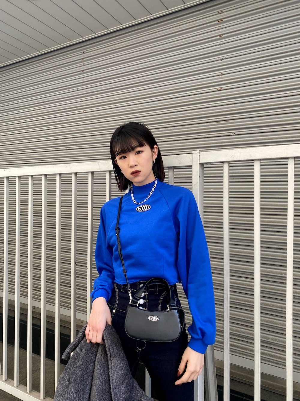 ブルー系のデニムパンツ、ブラック系のブーツ、ブルー系のスウェットを着用したレディースの冬コーディネートの6枚目の写真