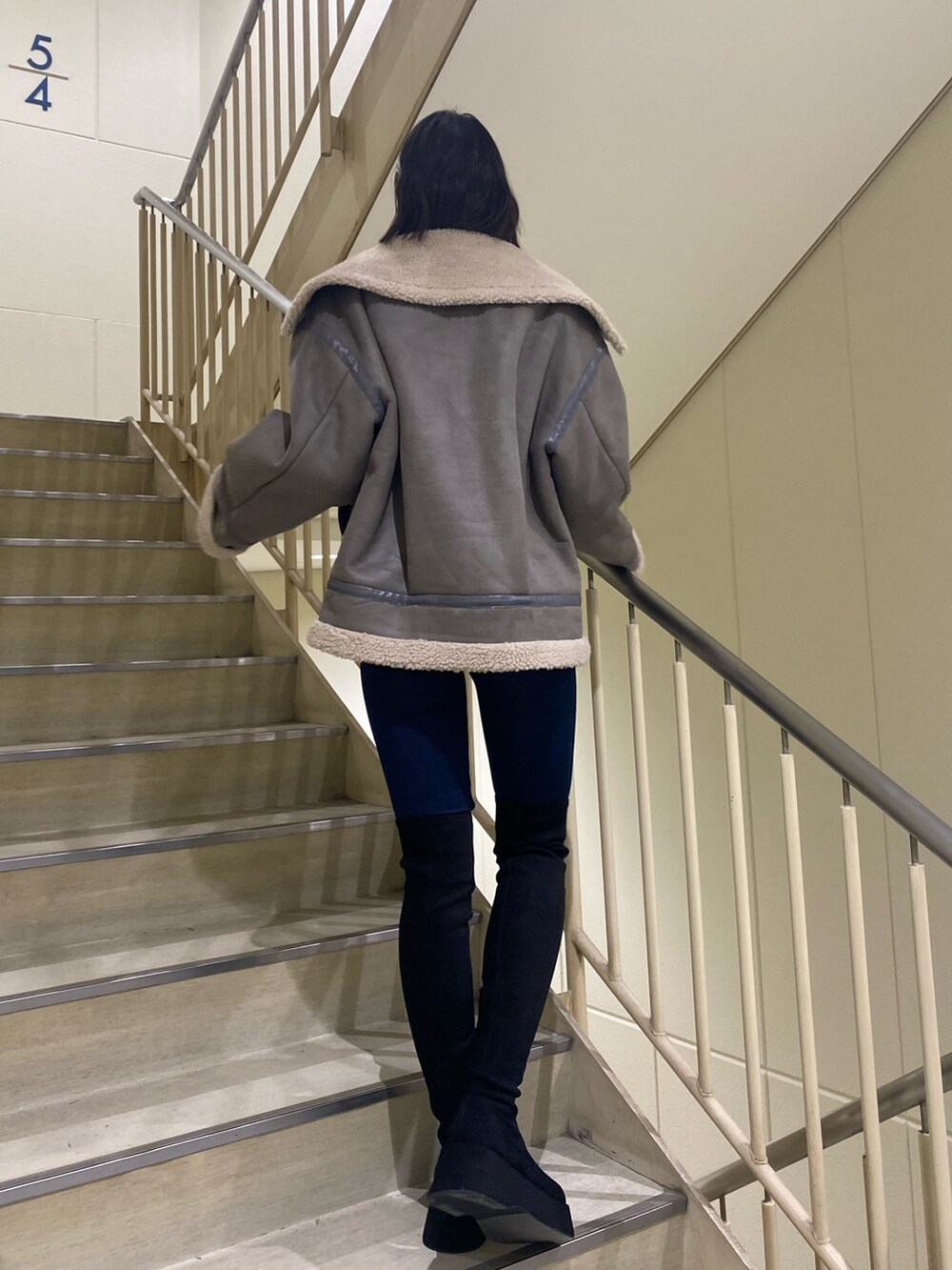 ブルー系のデニムパンツ、グレー系のブルゾン、ブラック系のニット/セーターを着用したレディースの冬コーディネートの10枚目の写真