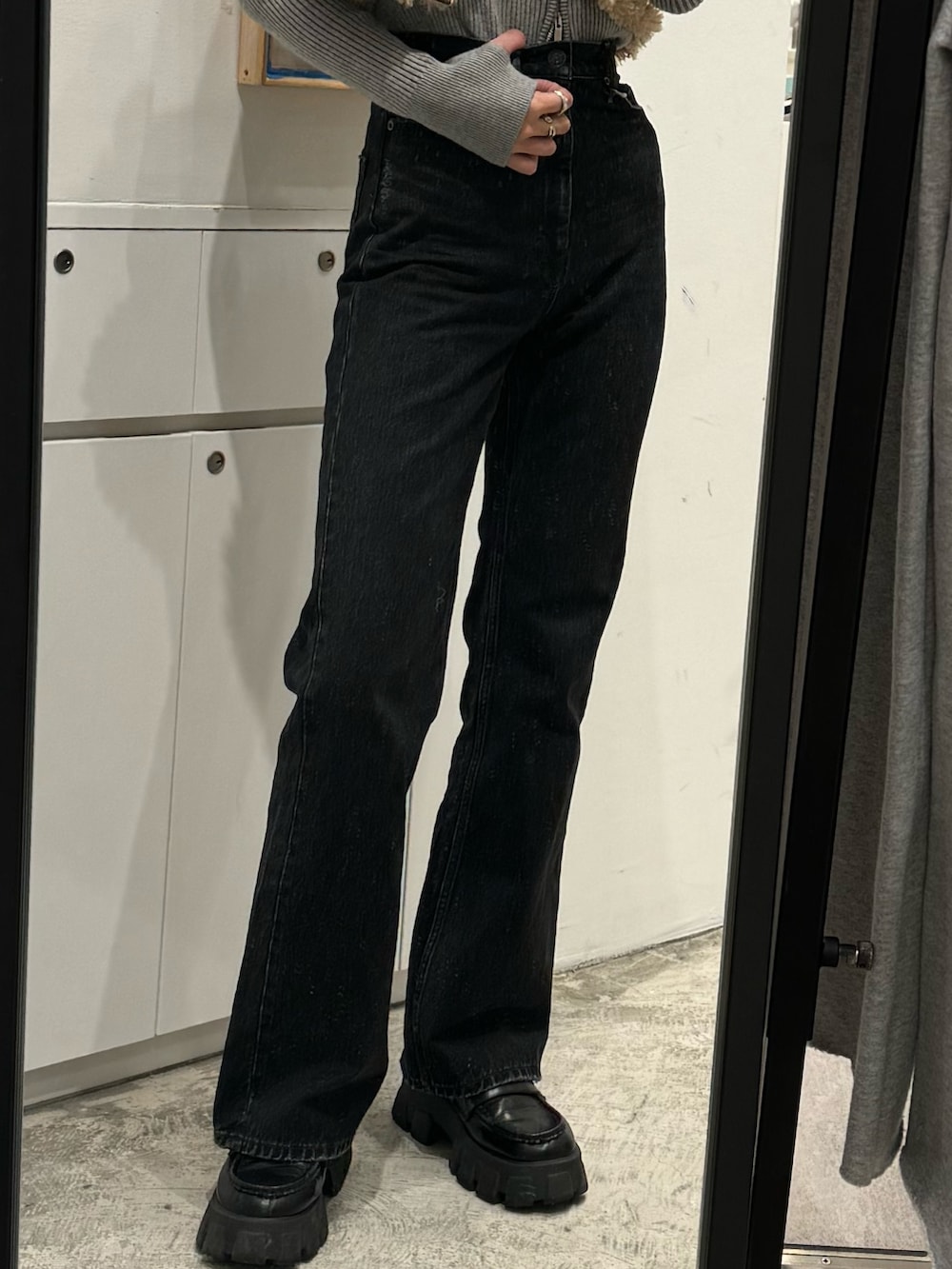 ブラック系のデニムパンツ、ブラウン系のベスト、グレー系のニット/セーターを着用したレディースの秋コーディネートの9枚目の写真